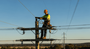 Electricity linesman working on power lines at height with safety equipment